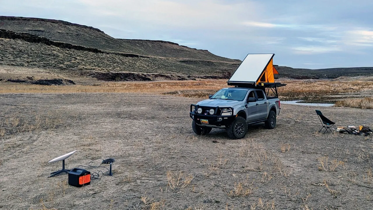 A truck with an orange tent on top of it.