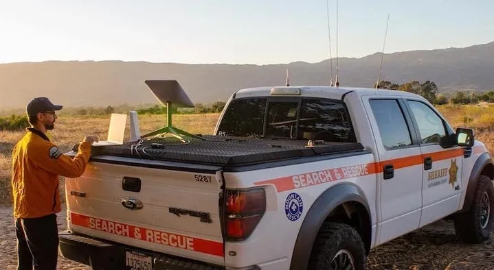 A white truck with an orange stripe on the back.